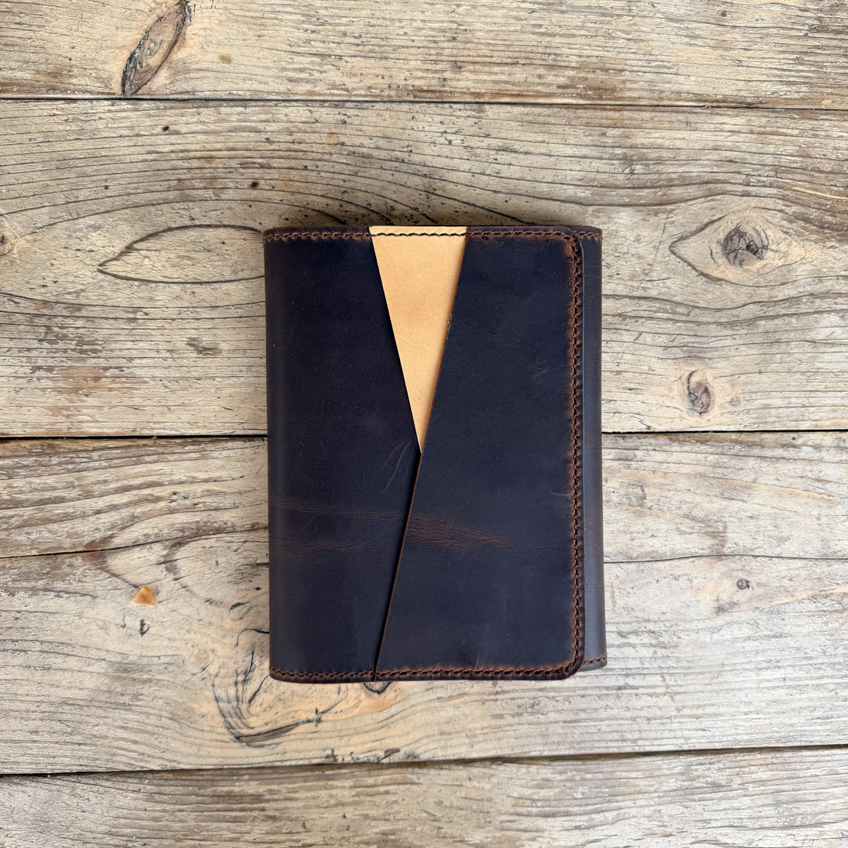 An A5 trifold cover in espresso leather with undyed leather for the accent pocket. 