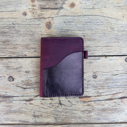 Closed Passport size leather cover in Beetroot leather with Glided Chocolate outer pocket